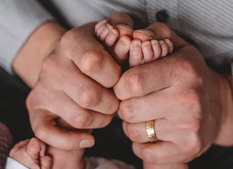 Babyvoetjes in de handen van papa en mama