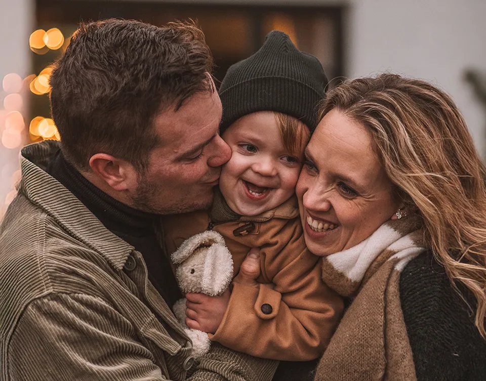Ouders geven hun zoontje samen een kus