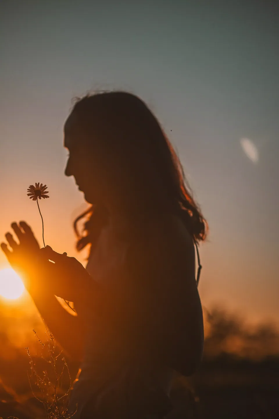 Silhouet van een vrouw in tegenlicht bij zonsondergang