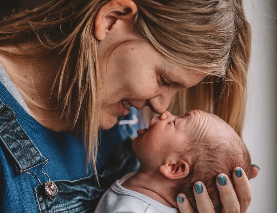 Mama houdt haar pasgeboren baby dicht tegen zich aan